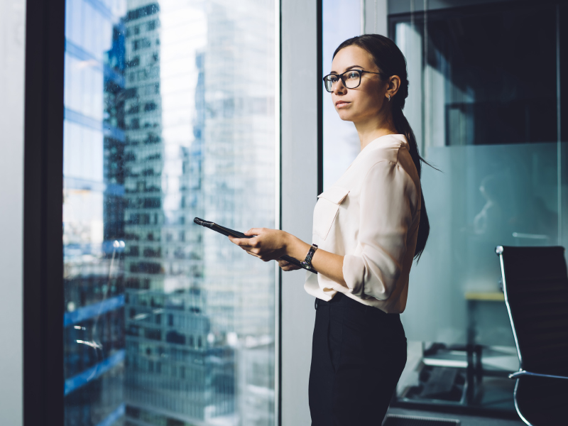 Confident woman reviewing financial documents, symbolizing the journey of managing wealth post-divorce or inheritance, as discussed in the blog.